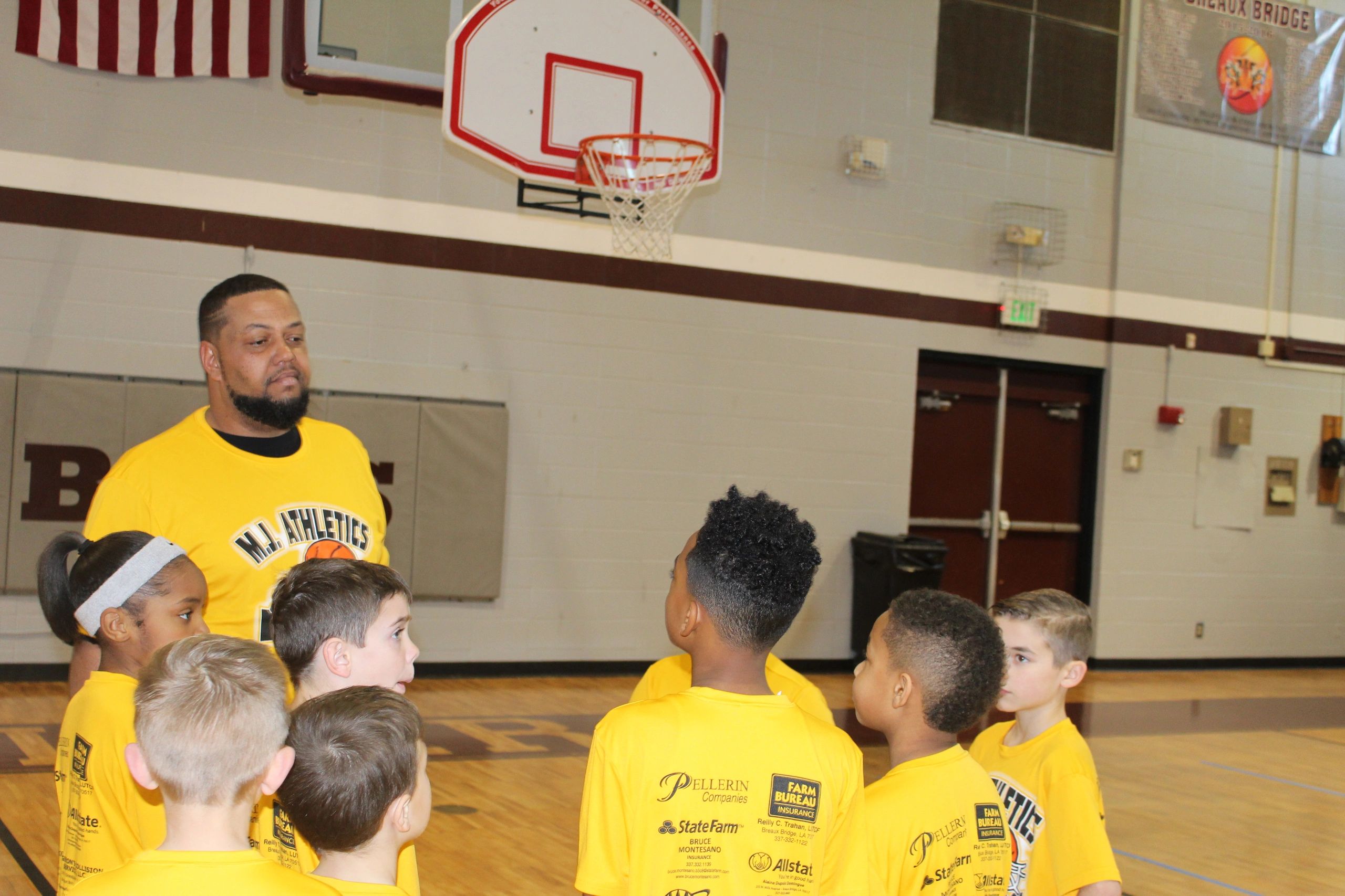 Youth basketball clinic with yellow team shirts